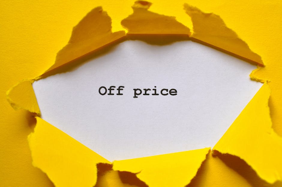 A close-up image showing a torn yellow paper revealing a white background underneath with the words 'Off price' printed in black. The torn edges are jagged and uneven, emphasizing the contrast between the bright yellow outer layer and the clean white surface. The overall composition suggests a focus on discounted or reduced pricing, relevant to domestic or commercial cleaning promotions. The lighting is even, highlighting the texture of the torn paper and the clarity of the text. The setting appears to be a flat surface with the torn paper placed centrally, used to draw attention to the message about special pricing or discounts associated with cleaning services. The image is relevant to surface cleaning and deep cleaning themes promoted by Maida Vale Carpet Cleaners, aligning with the context of the page discussing hidden charges in cleaning quotes.